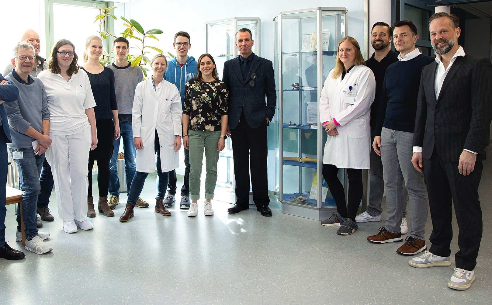 Gruppenbild der Projektpartner mit 14 Männern und Frauen gemischten Alters in einem Krankehaus.